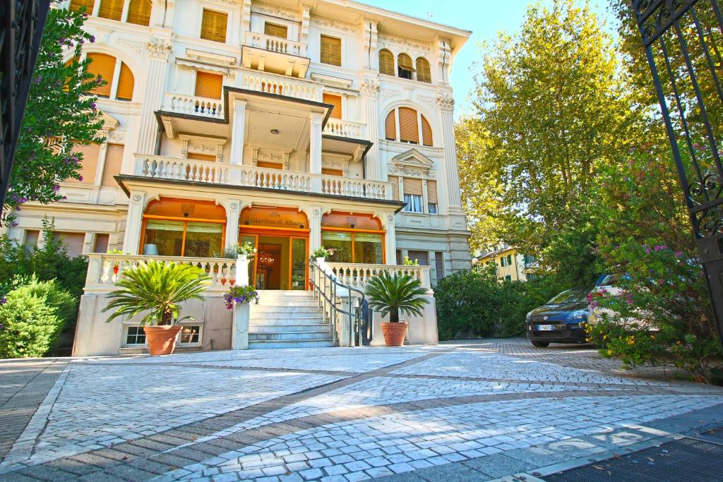 un grand bâtiment blanc avec des plantes en pot devant lui dans l'établissement Il Giardino Di Albaro, à Gênes