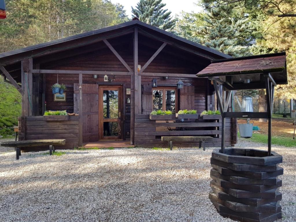 a wooden cabin with a door and a bench at Baita Nel Bosco in LʼAquila