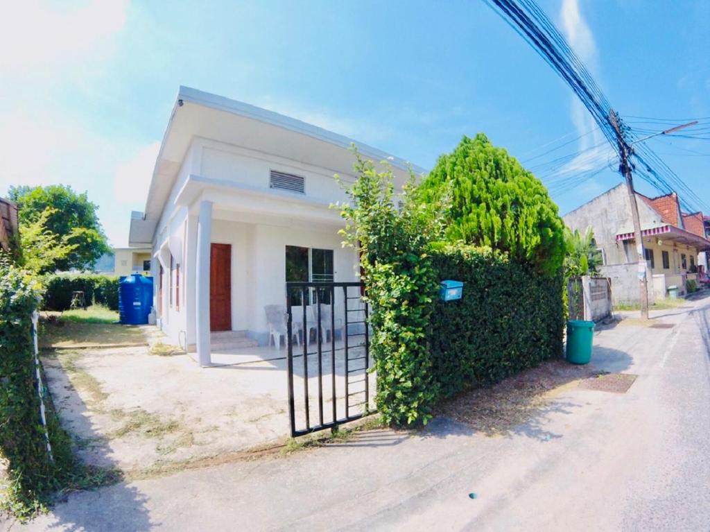 a white house with a gate in front of it at The Endless Bangtao Residence TV2 AND TV 3 in Bang Tao Beach
