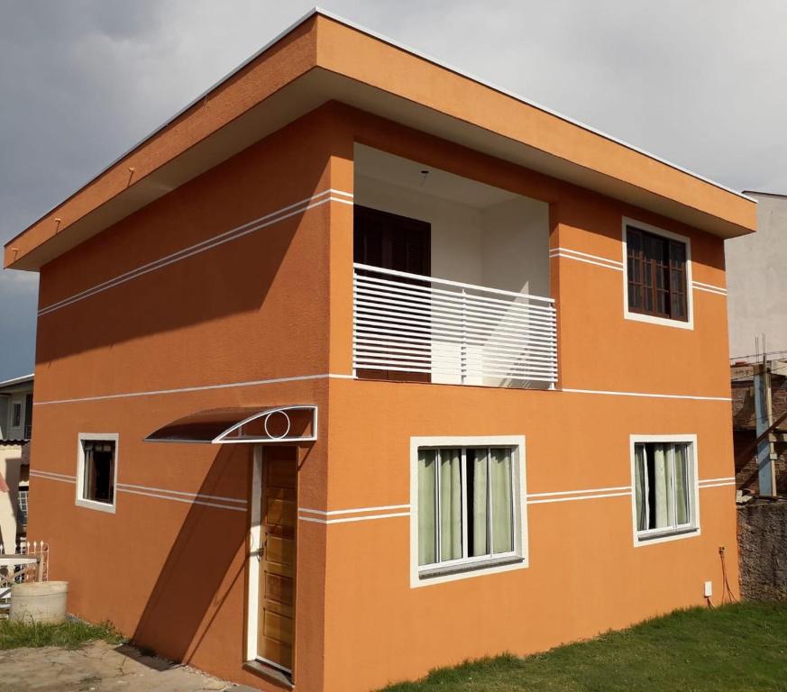 une petite maison avec une orange dans l'établissement Casa de Hospede Santa Felicidade, à Curitiba