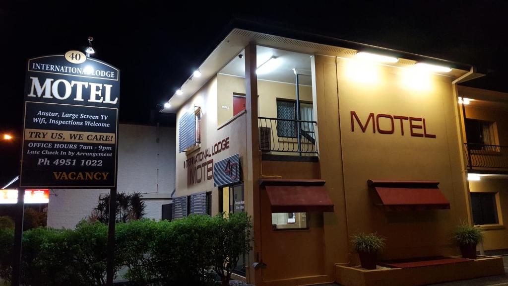 a motel sign in front of a building at night at International Lodge Motel in Mackay