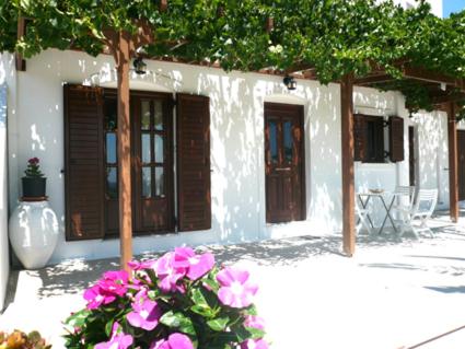 a white building with purple flowers in front of it at Ariston Apartments in Serifos Chora