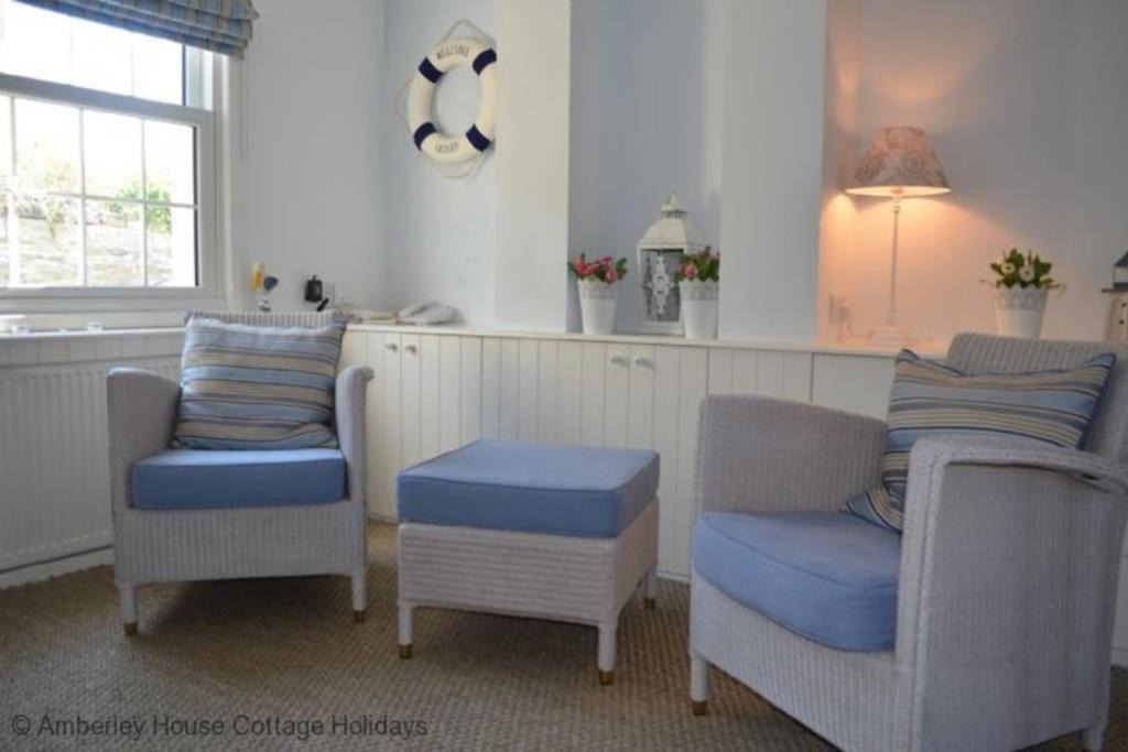 a living room with two chairs and a table at Tackleway Cottage in Hastings