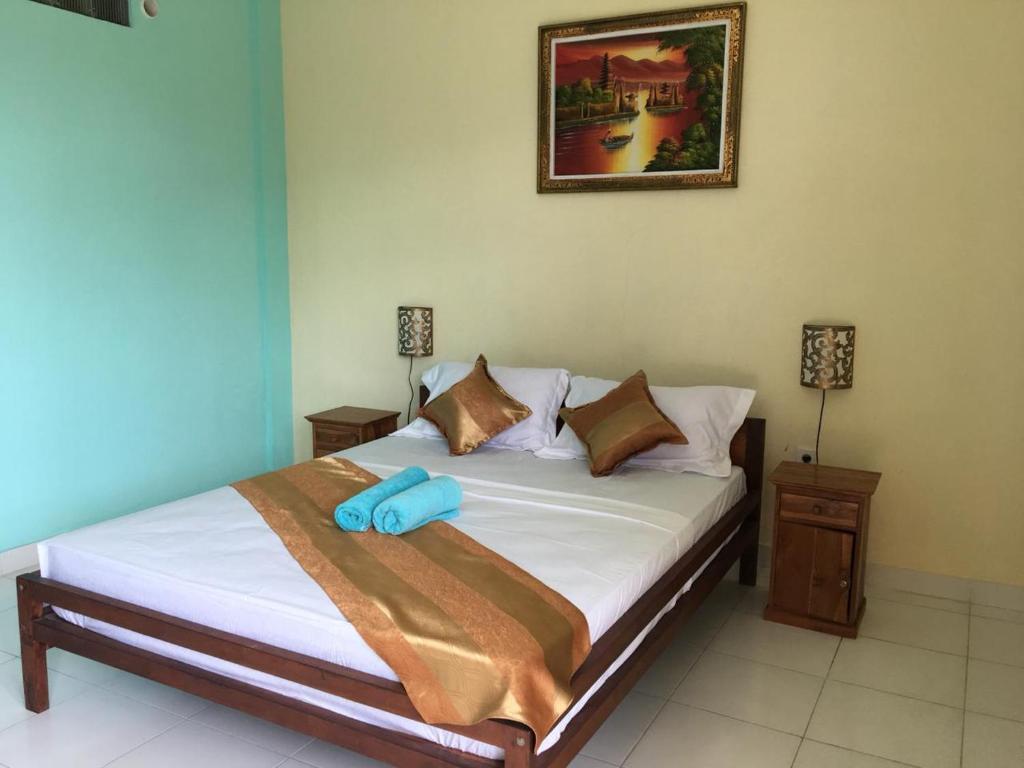 a bedroom with a bed with two blue objects on it at Repag Wayan Canggu Hostel in Canggu