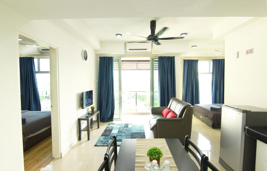 een woonkamer met een bank en een eettafel bij 10:39 Studio @ D'Perdana Sri Cemerlang in Kota Bharu