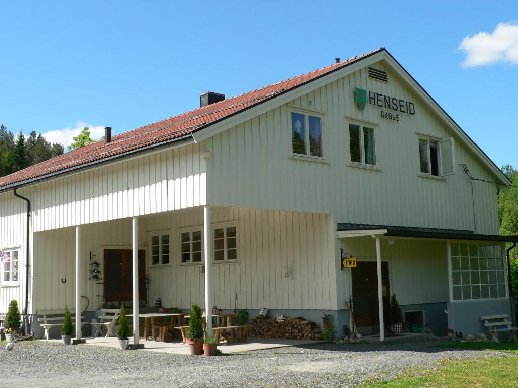 um grande edifício branco com garagem em Henseid Skole em Hennseid