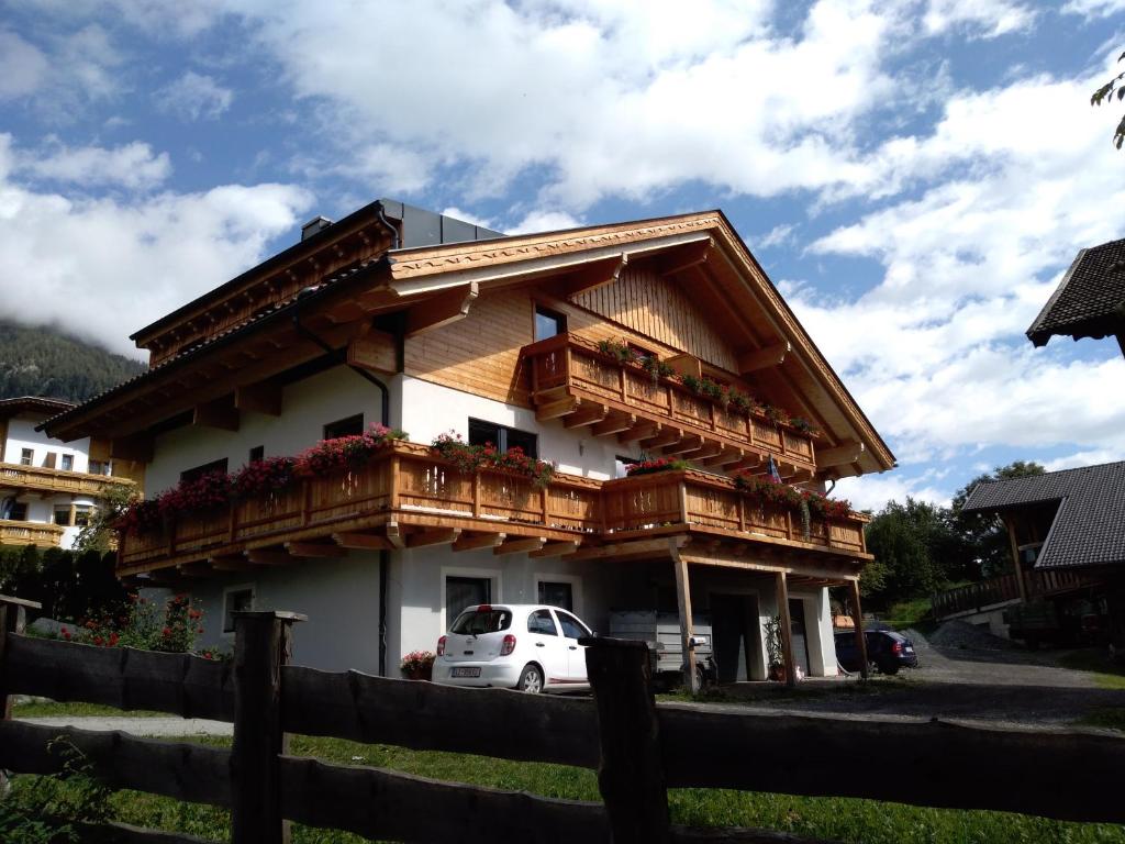 una casa con balconi e una macchina parcheggiata di fronte di Oberrollerhof a Virgen