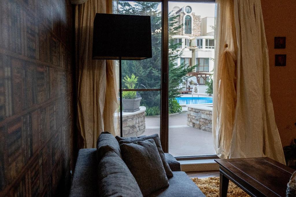 uma sala de estar com um sofá e uma grande janela em Tenerra Lux Apartment em Varna City