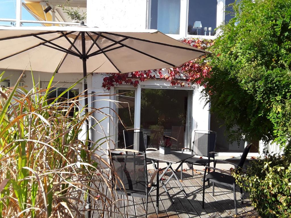 a table and chairs under an umbrella on a patio at FeWo Charlotte in Horn-Bad Meinberg