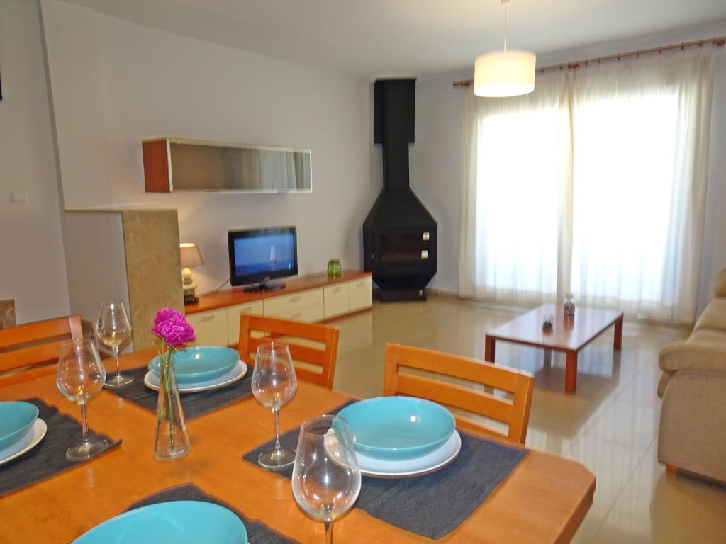 una sala da pranzo con tavolo, piatti e bicchieri di SAN FERNANDO PALACE III - Beach House a Oliva