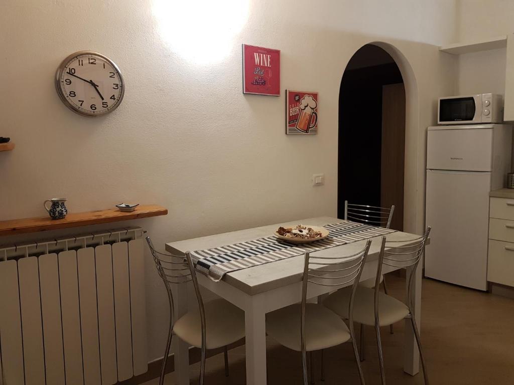 eine Küche mit einem Tisch mit Stühlen und einer Uhr an der Wand in der Unterkunft IL MARMO (CITRA 011017-LT-0069) in Levanto