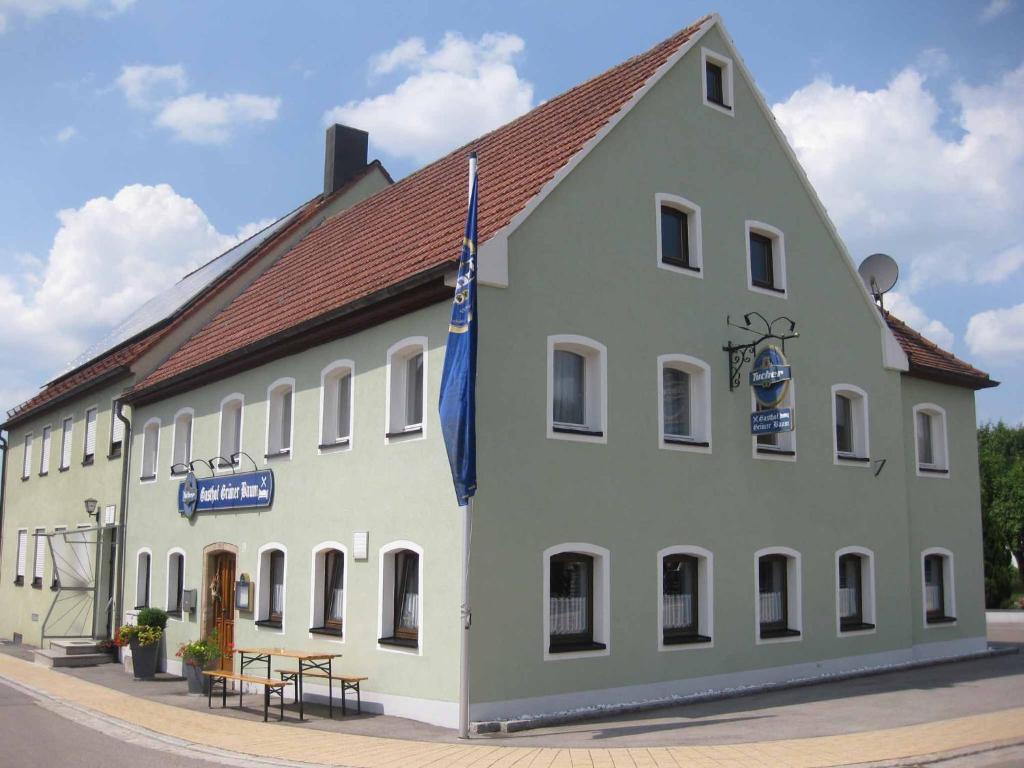 a large white building with a flag on it at Gasthof Grüner Baum in Oberlangfurth