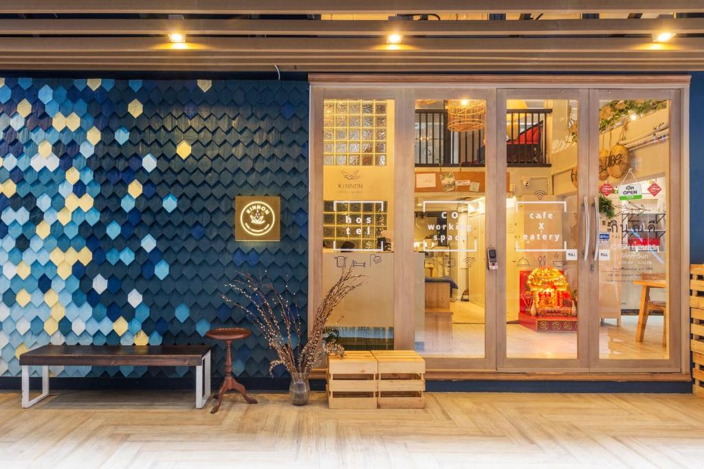 a store front with a blue and white wall at Kinnon Deluxe Hostel Coworking Cafe in Bangkok