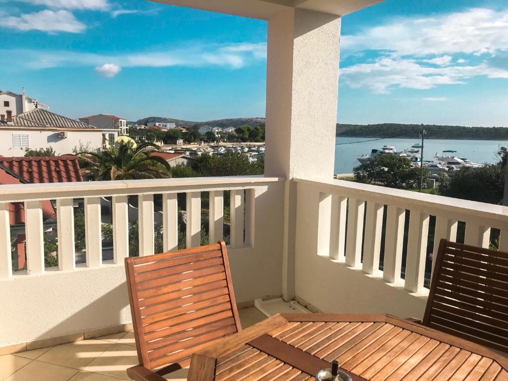 Un balcón con mesa y sillas y vista al agua. en MR. HALL Apartments, en Barbat na Rabu