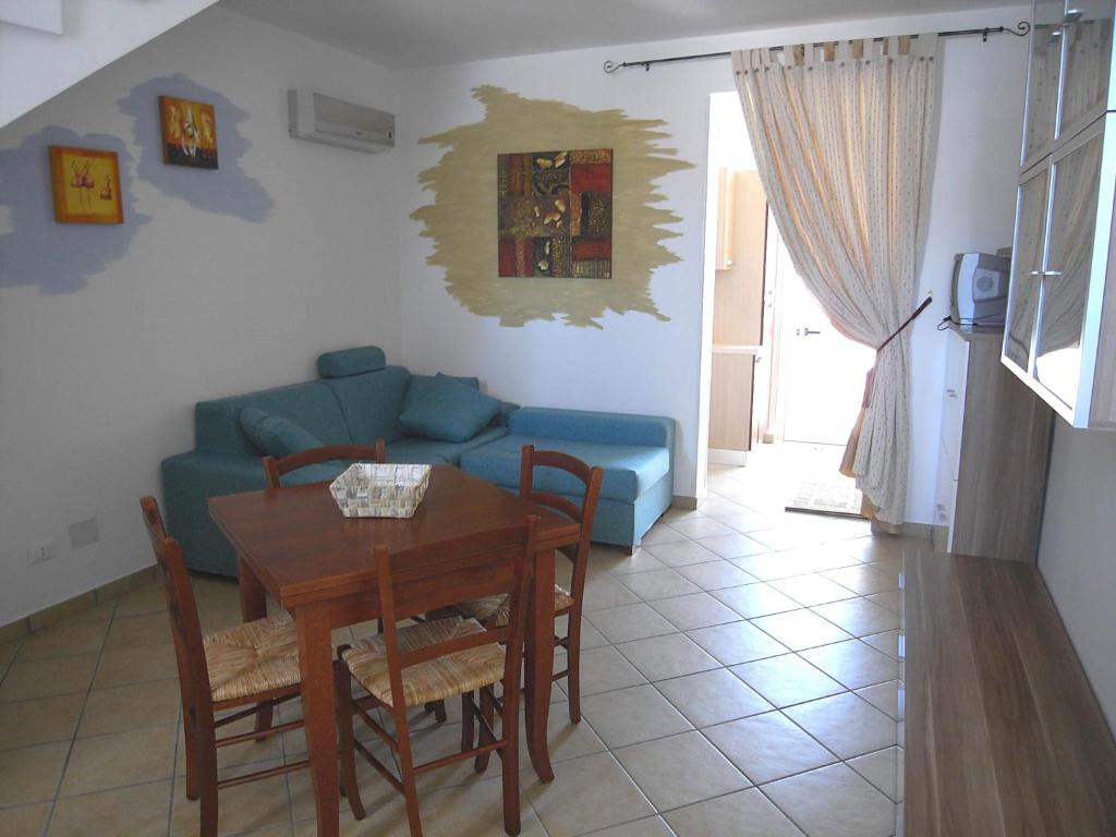 un soggiorno con tavolo e divano blu di Casa Maura by RENTHOUSESALENTO a San Foca