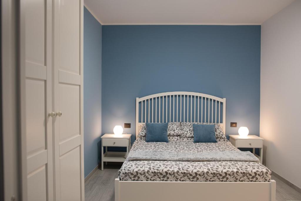 sypialnia z dużym łóżkiem z niebieskimi ścianami w obiekcie HOB Via Rausei w mieście Reggio di Calabria
