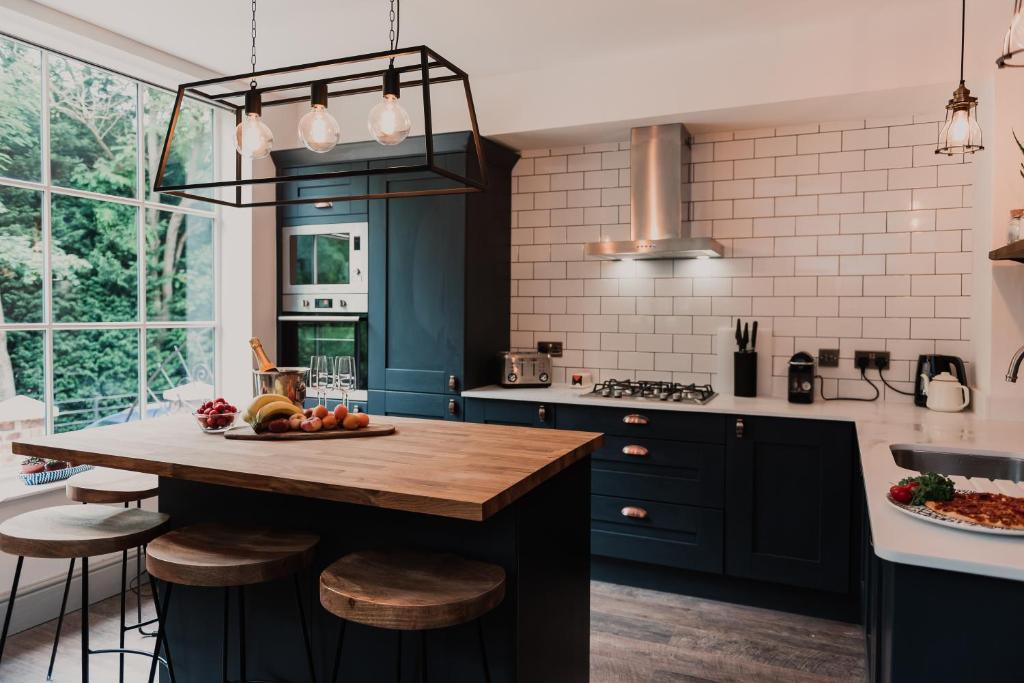 a kitchen with blue cabinets and a wooden counter top at Penny Black Cottage in Coalbrookdale