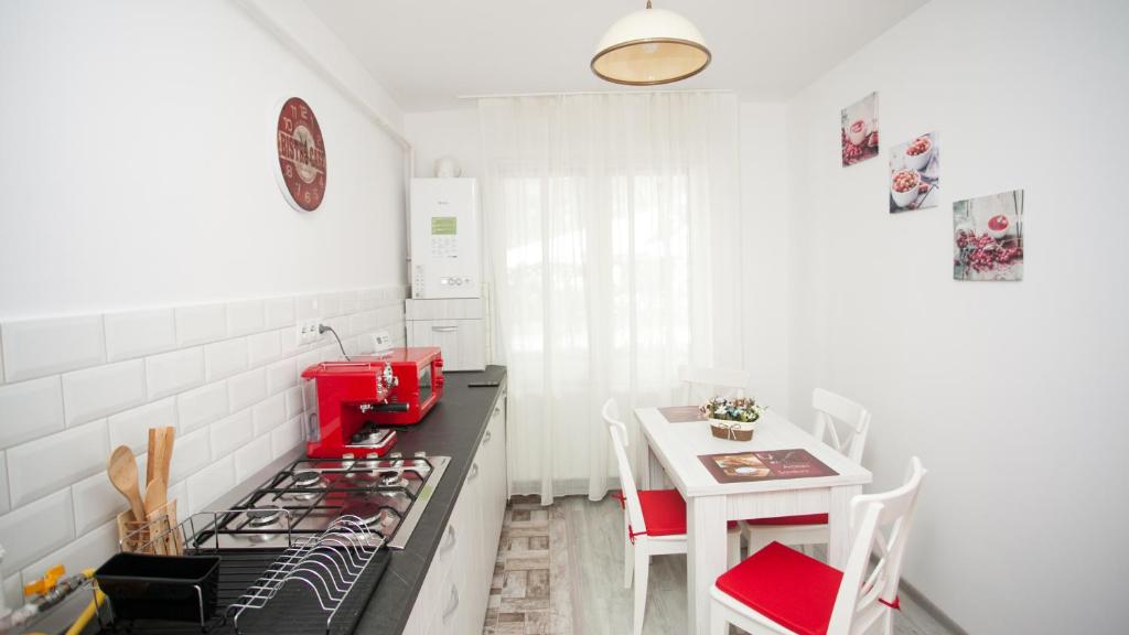 a kitchen with a stove and a small table at Apartament Elena in Târgu-Mureş