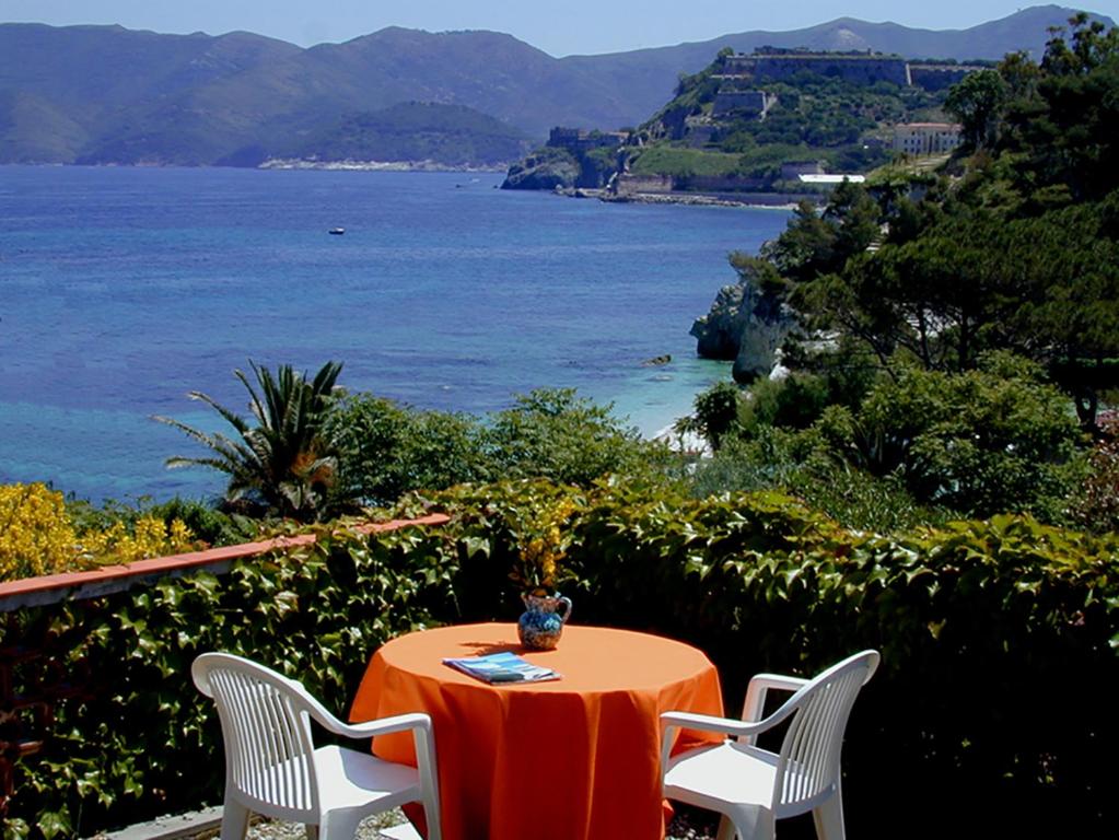 a table and chairs with a view of the ocean at Residence Capobianco in Portoferraio