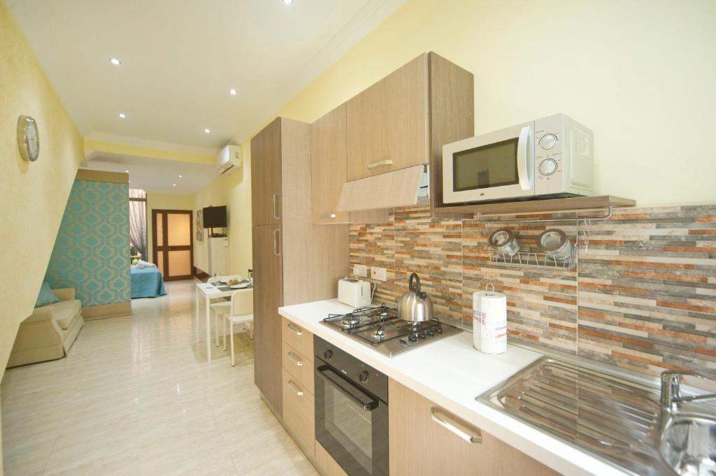 een keuken met een wastafel en een magnetron bij Sliema duplex 1 bedroom apartment - Sleeps 4 in Sliema