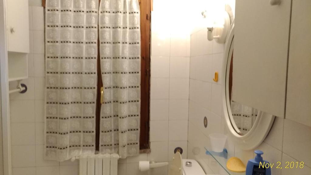 y baño con cortina de ducha y lavamanos. en Casa a Soliera, en Il Cristo