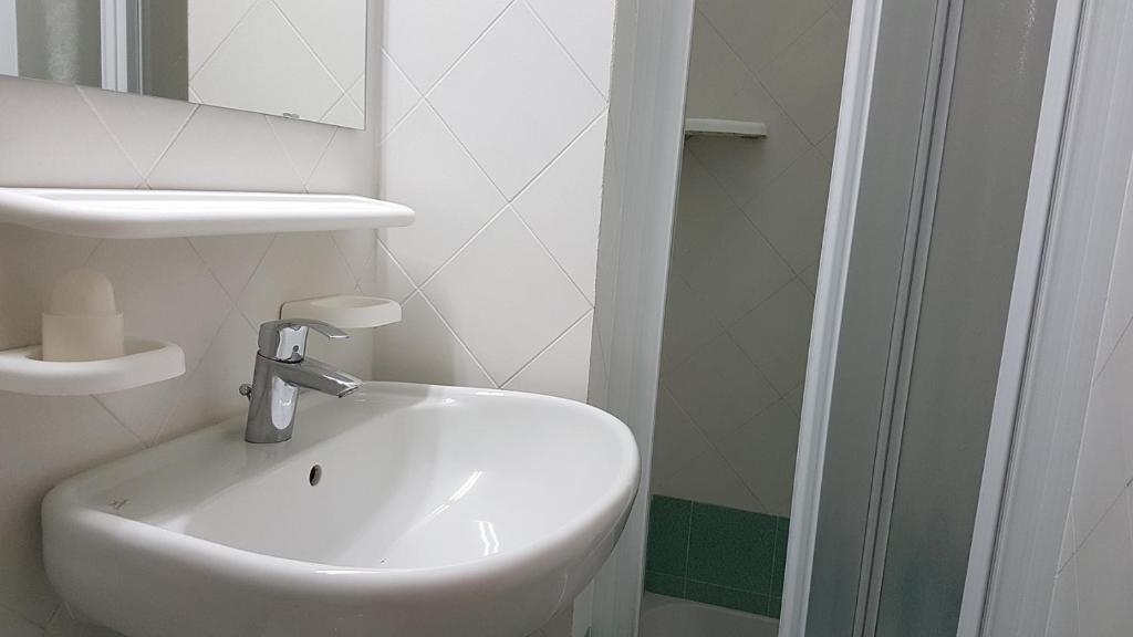 a bathroom with a white sink and a mirror at Residence Capobianco in Portoferraio