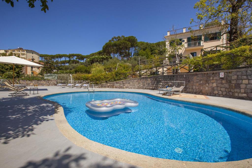 a swimming pool with a slide in the middle of it at Amore Rentals - Residence Bosco in SantʼAgata sui Due Golfi