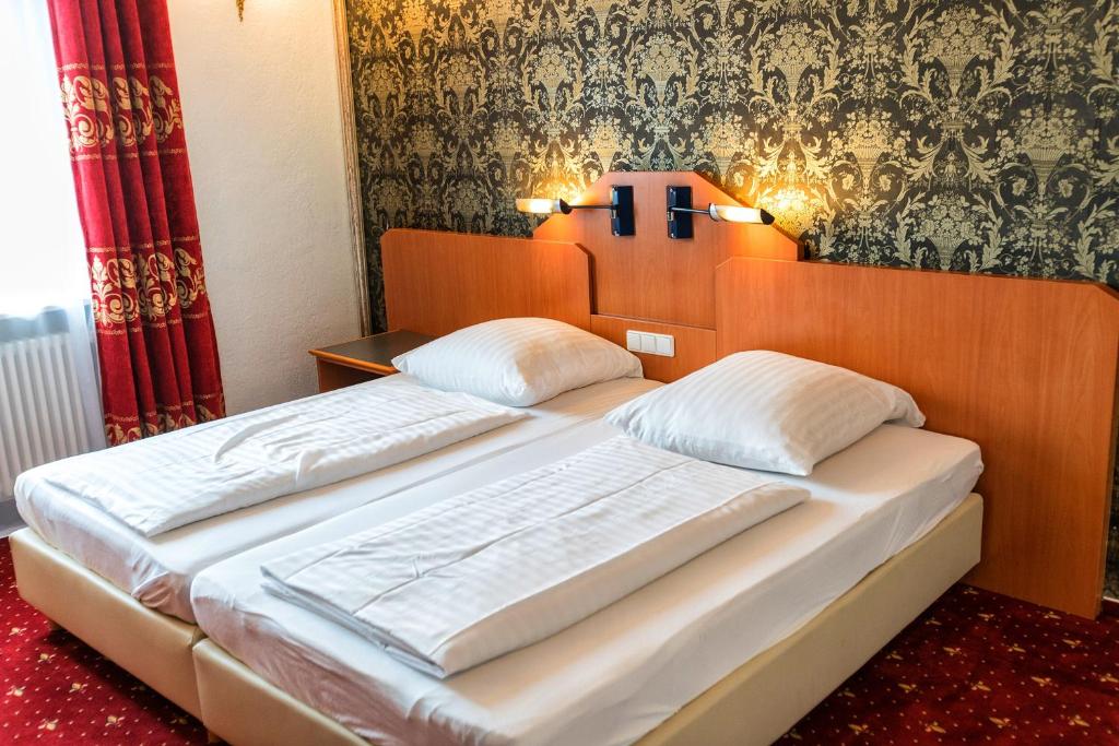 a bedroom with two beds in a room at Hotel Krone in Friesenheim