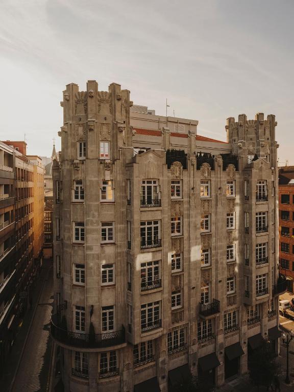 an old stone building in the middle of a city at El Môderne Hotel in Gijón