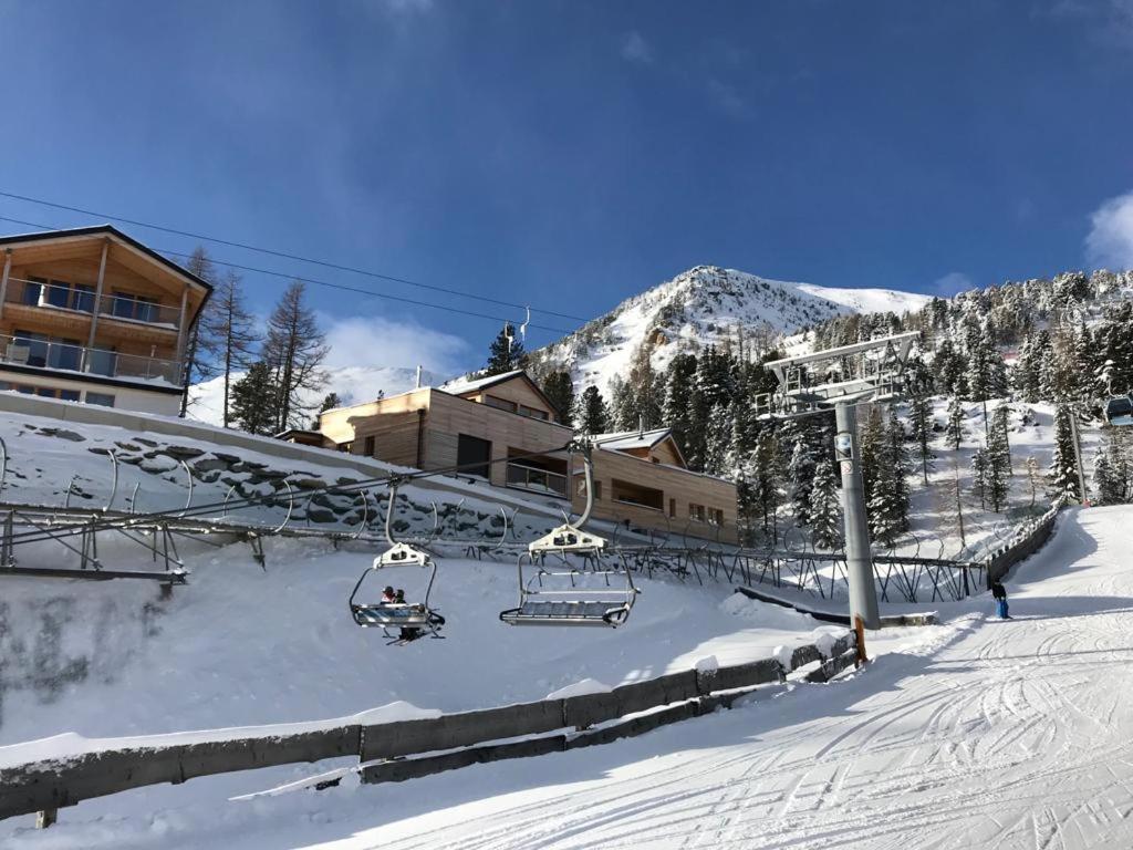 a ski lift with people on it in the snow at Apartment Ski in - Ski out in Turracher Hohe