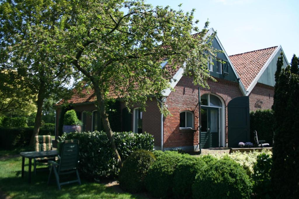 a red brick house with a table in the yard at De Borg Vakantie Appartementen in Winterswijk