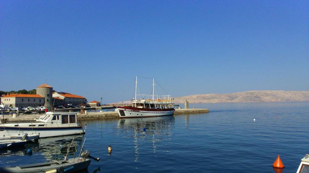 two boats are docked at a dock in the water at Apartment Marino in Senj