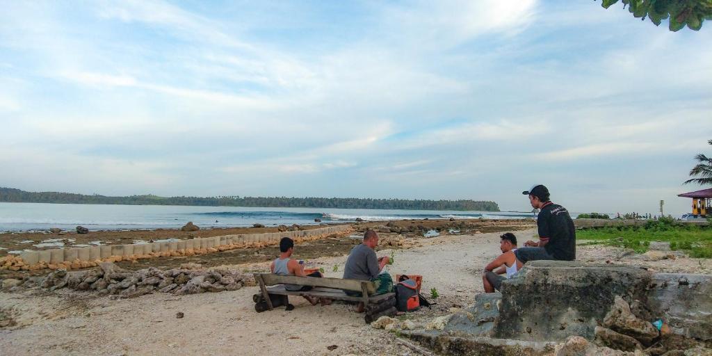 a group of people sitting on the beach at Dolin Cottage in Hilibotodane