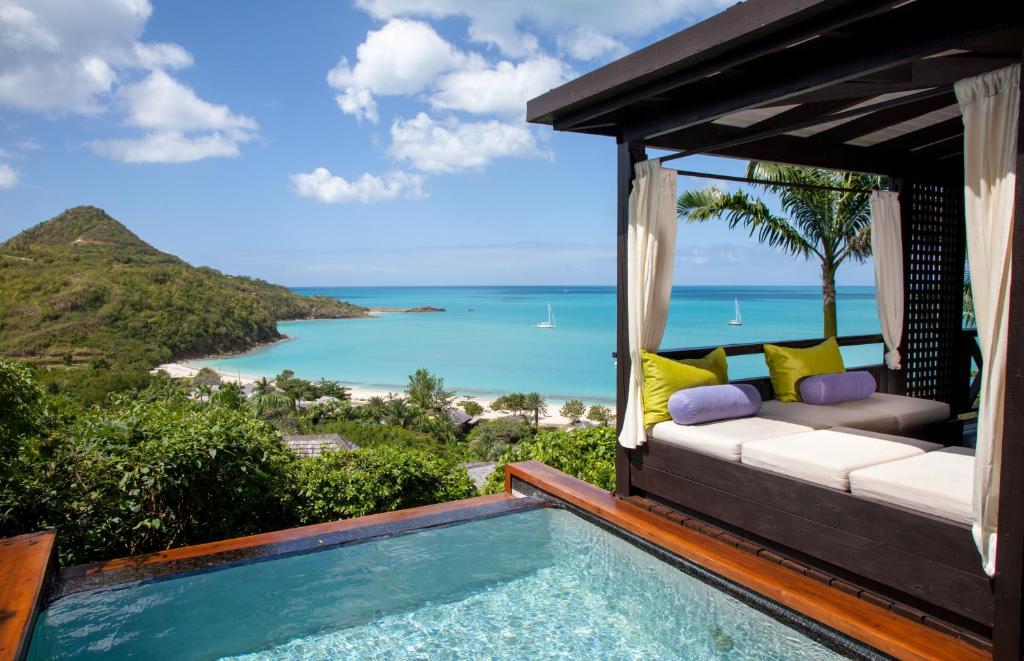 a villa with a swimming pool and a view of the ocean at Hermitage Bay - All Inclusive in Saint Johnʼs