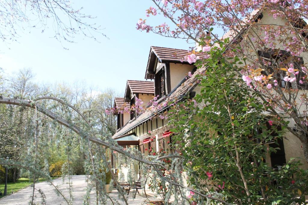 a building with pink flowers on the side of it at Chambres d'hôtes La Brillève in Lamotte-Beuvron