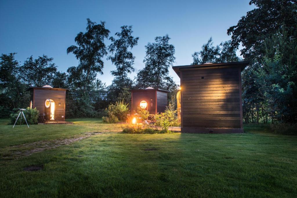 two tiny homes in a field at night at Sterrenkubus in Lattrop