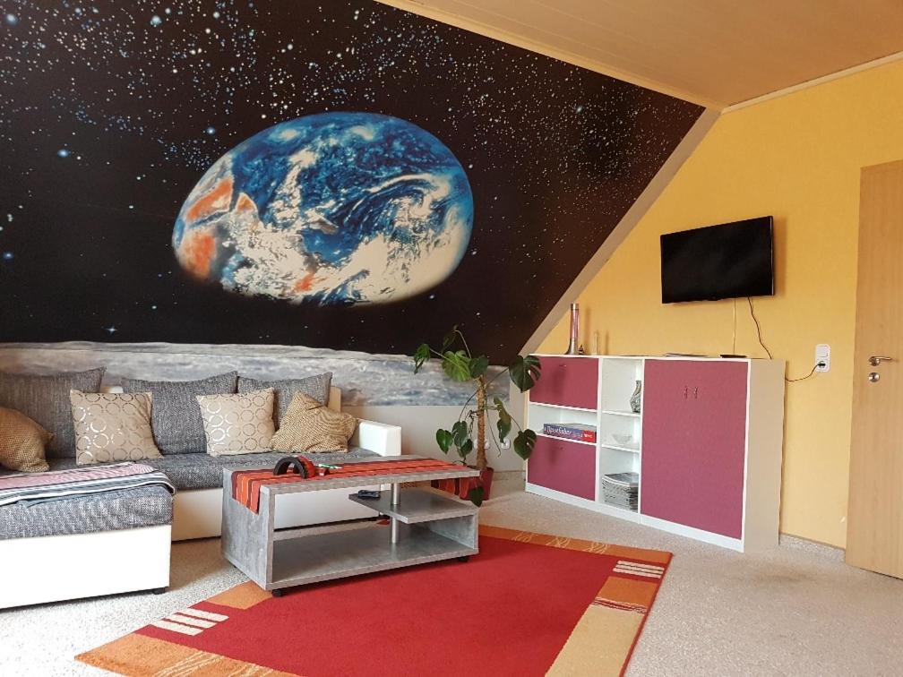 a living room with a planet mural on the wall at Kunst und Kultur in Weimar in Weimar