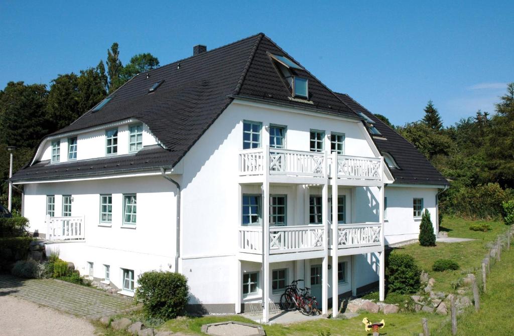ein großes weißes Haus mit schwarzem Dach in der Unterkunft Ferienhaus Südstrand in Göhren