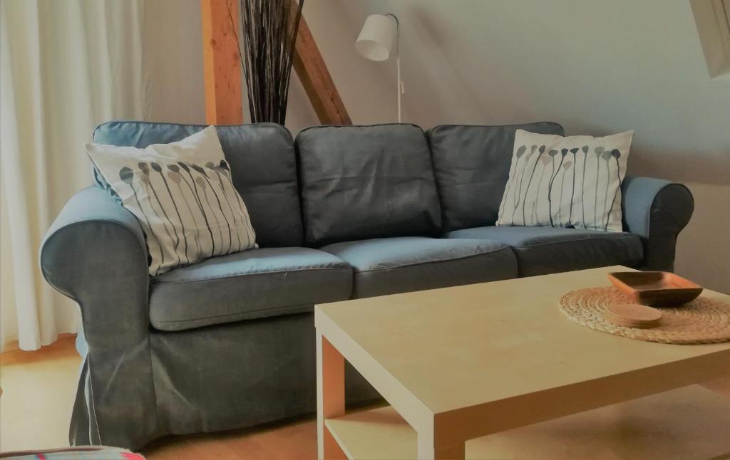 ein blaues Sofa im Wohnzimmer mit einem Tisch in der Unterkunft Ferienwohnung Bad Oldesloe in Bad Oldesloe