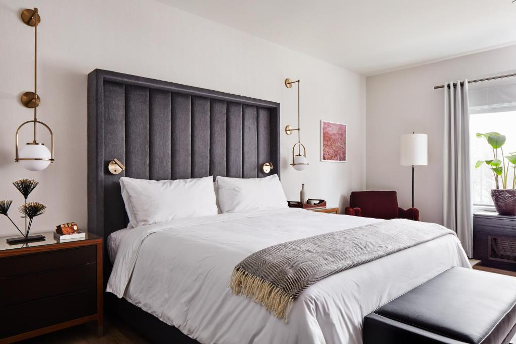 1 dormitorio con 1 cama grande y cabecero negro en The Blake Hotel en New Haven