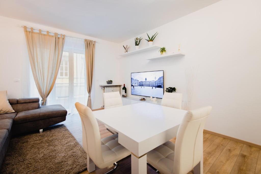 a white dining room with a white table and chairs at La Boutique del Vento - Esclusivo in pieno centro in Trieste