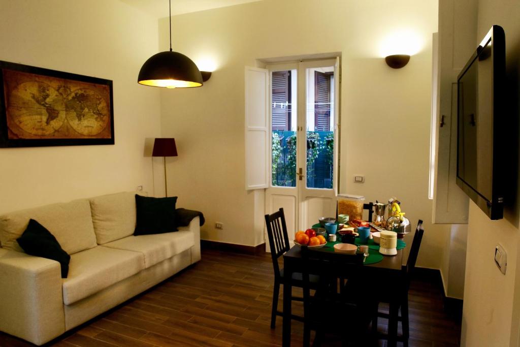 un soggiorno con divano e tavolo con cibo sopra di Paola's Apartment in the heart of Trastevere, Roma a Roma