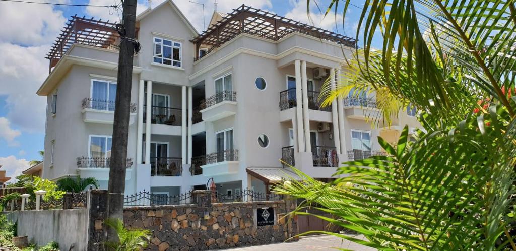 a large white house with balconies and trees at Northern Pearl Luxury Apartments in Mont Choisy