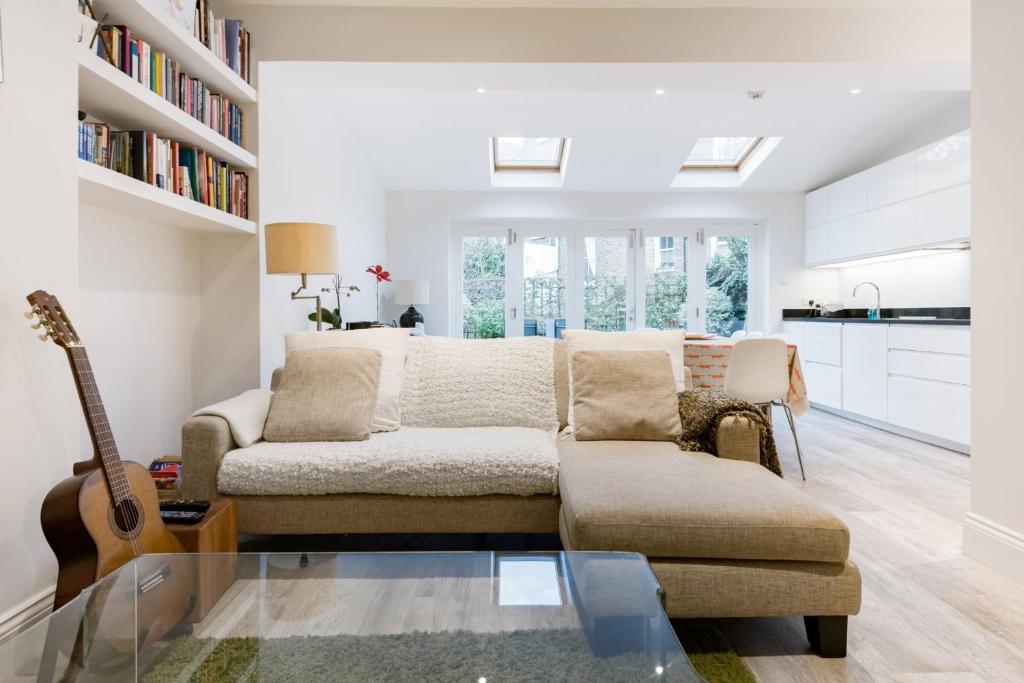 a living room with a couch and a guitar at Tadmor Townhouse in London