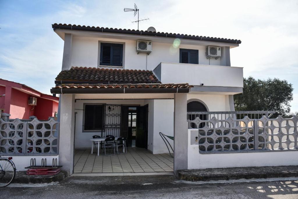 a white house with a fence in front of it at Villa Mary in Torre Lapillo
