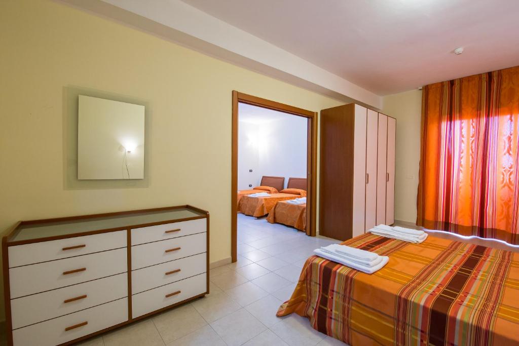 a bedroom with two beds and a dresser and a mirror at Hotel Villaggio S. Antonio in Isola Capo Rizzuto