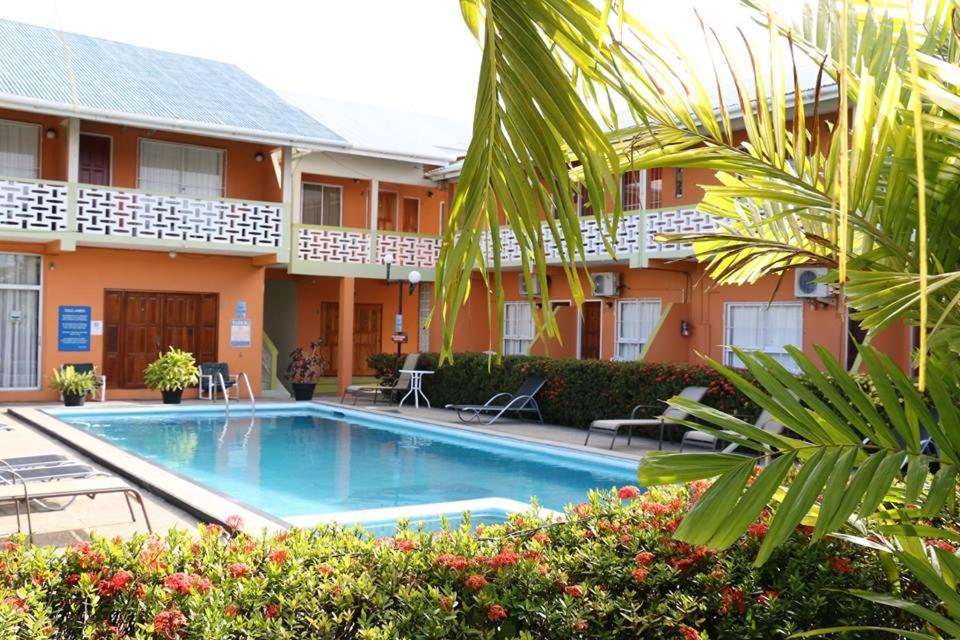 a hotel with a swimming pool in front of a building at Viola's Place in Lowlands