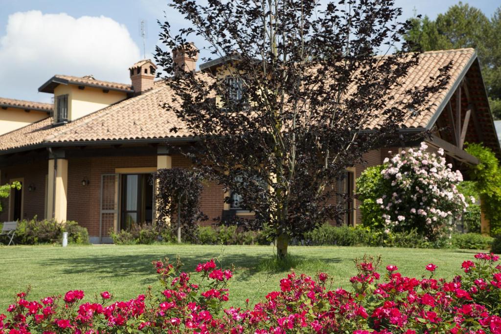 una casa con flores rosas delante de ella en B&B La Frola, en Baldissero Torinese