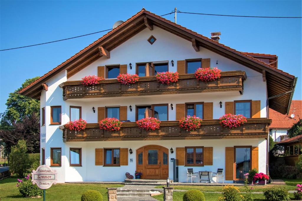 una casa blanca con flores en el balcón en Gästehaus Sonner en Dietmannsried