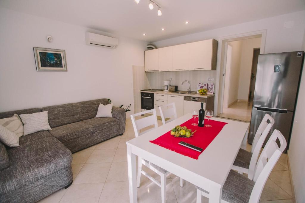 een keuken en een woonkamer met een tafel en een bank bij Apartments Jasna in Podstrana
